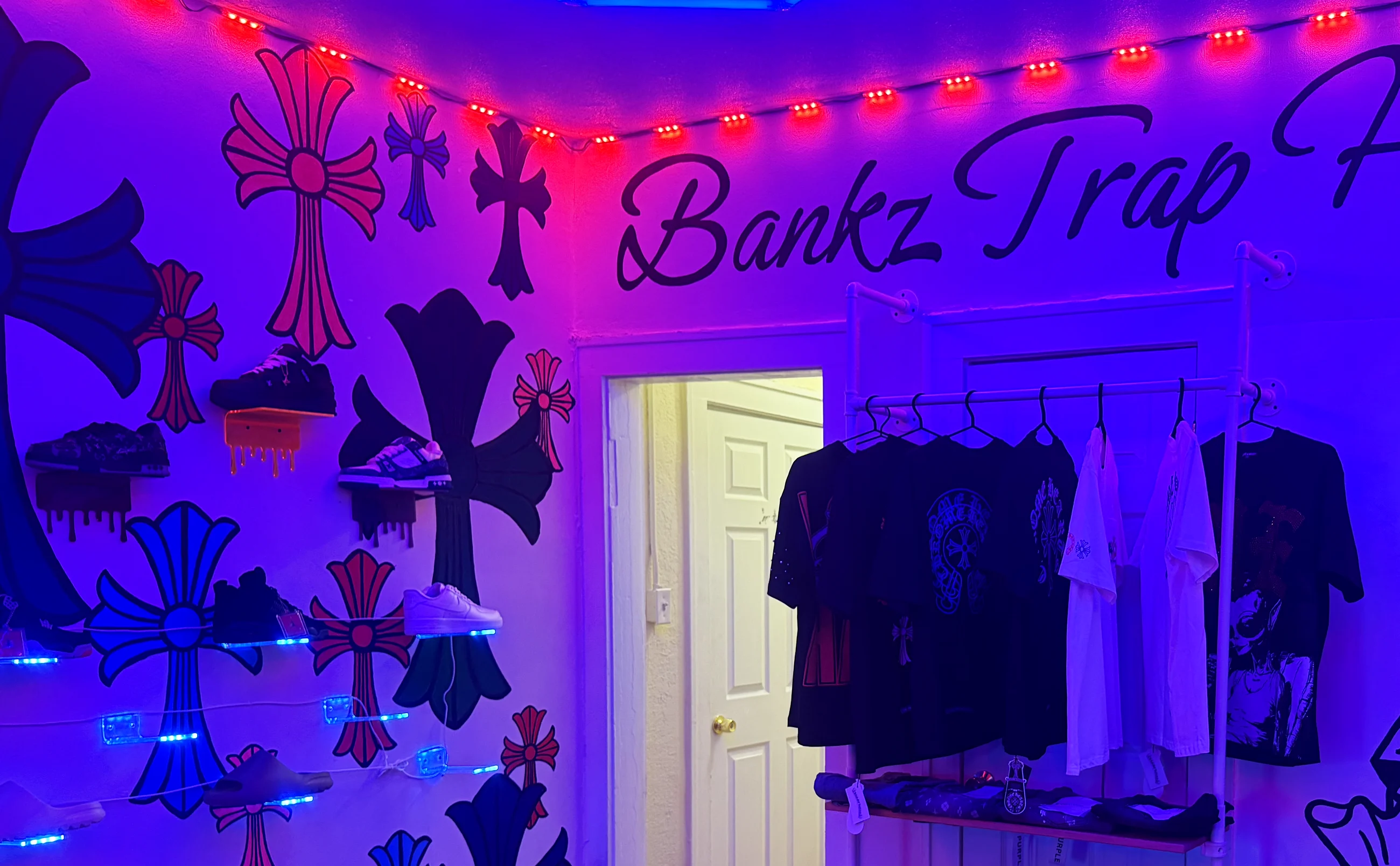 Interior of Bankz Trap House: hand-painted cross wall, hex-lit ceiling, and the Bankz Trap House script across the top